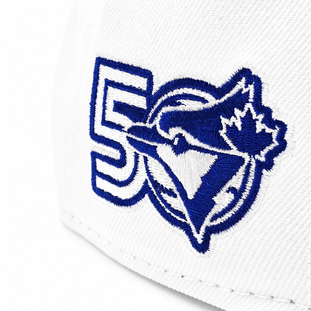 Close-up of a white baseball cap featuring a blue embroidered Toronto Blue Jays logo with a large number 5 integrated into the design.