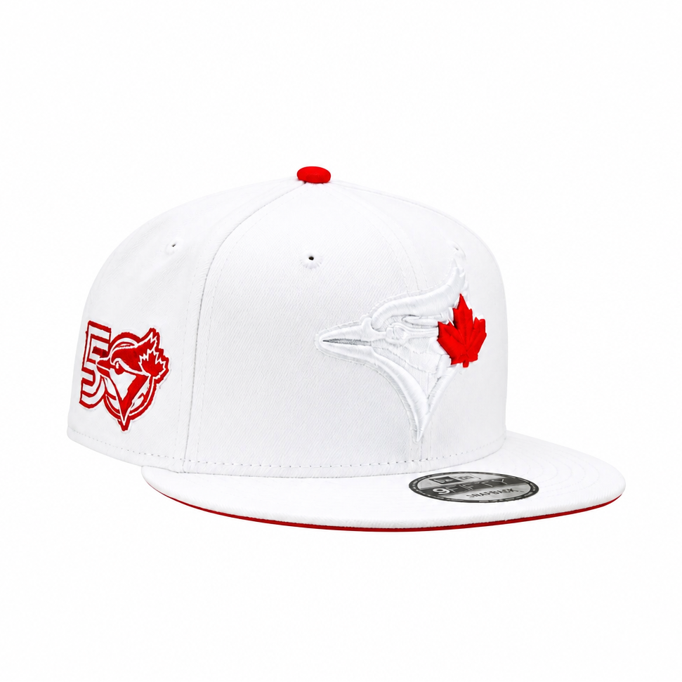 A white Toronto Blue Jays 59FIFTY fitted cap featuring a red maple leaf logo on the front, a red embroidered '50' with a blue jay graphic on the side, and a red brim edge, shown against a plain white background.