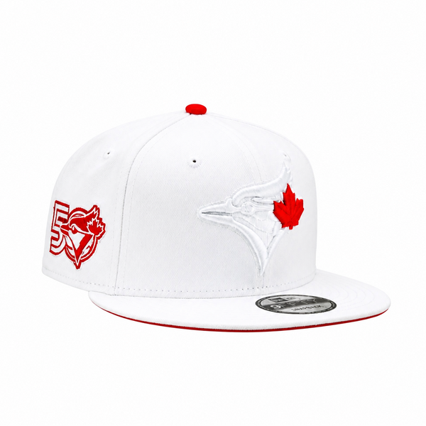 A white Toronto Blue Jays 59FIFTY fitted cap featuring a red maple leaf logo on the front, a red embroidered '50' with a blue jay graphic on the side, and a red brim edge, shown against a plain white background.