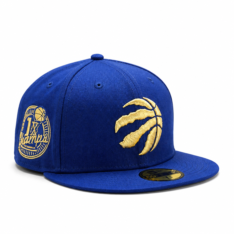 A royal blue fitted baseball cap with gold embroidery, featuring a basketball logo on the front and a championship patch on the side, set against a plain white background.